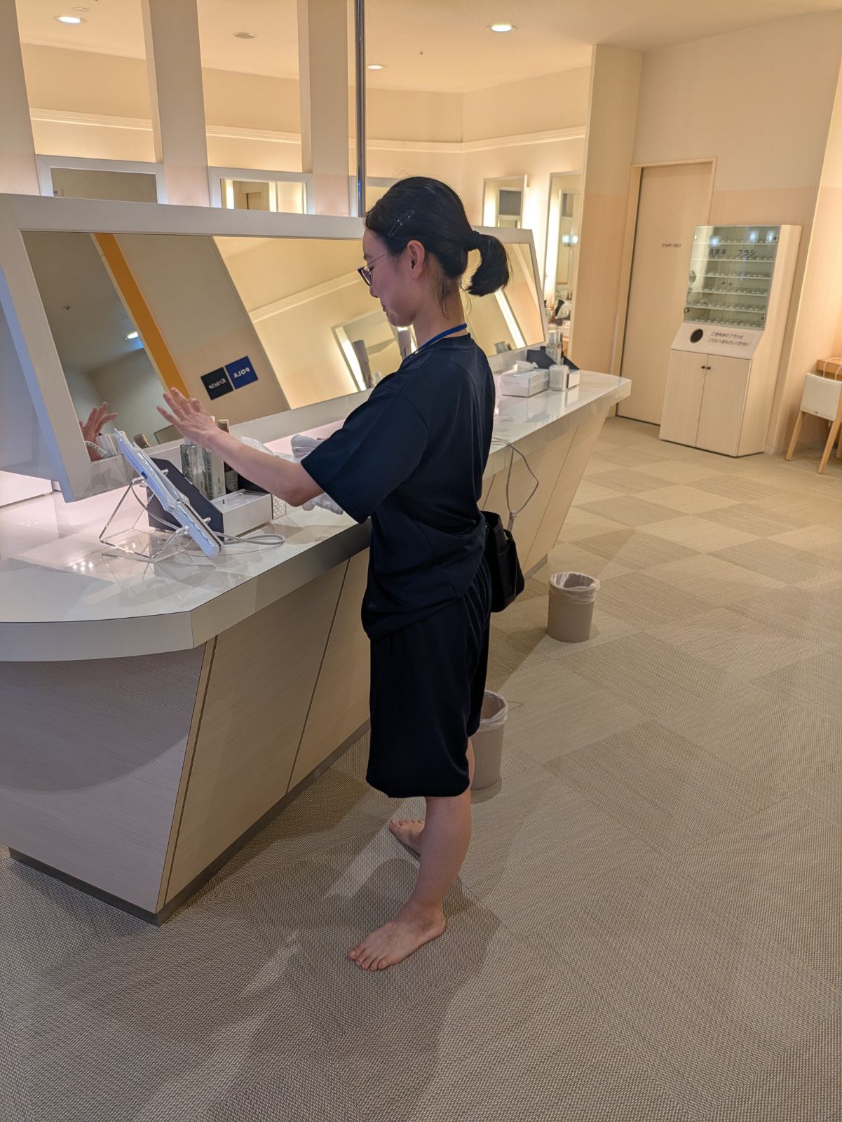 SPA EAS様のパウダールームで鏡や備品まわりを確認するスタッフ