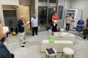 スーパーサウナ一宮様で資料を確認しながらスタッフが集まる研修の様子