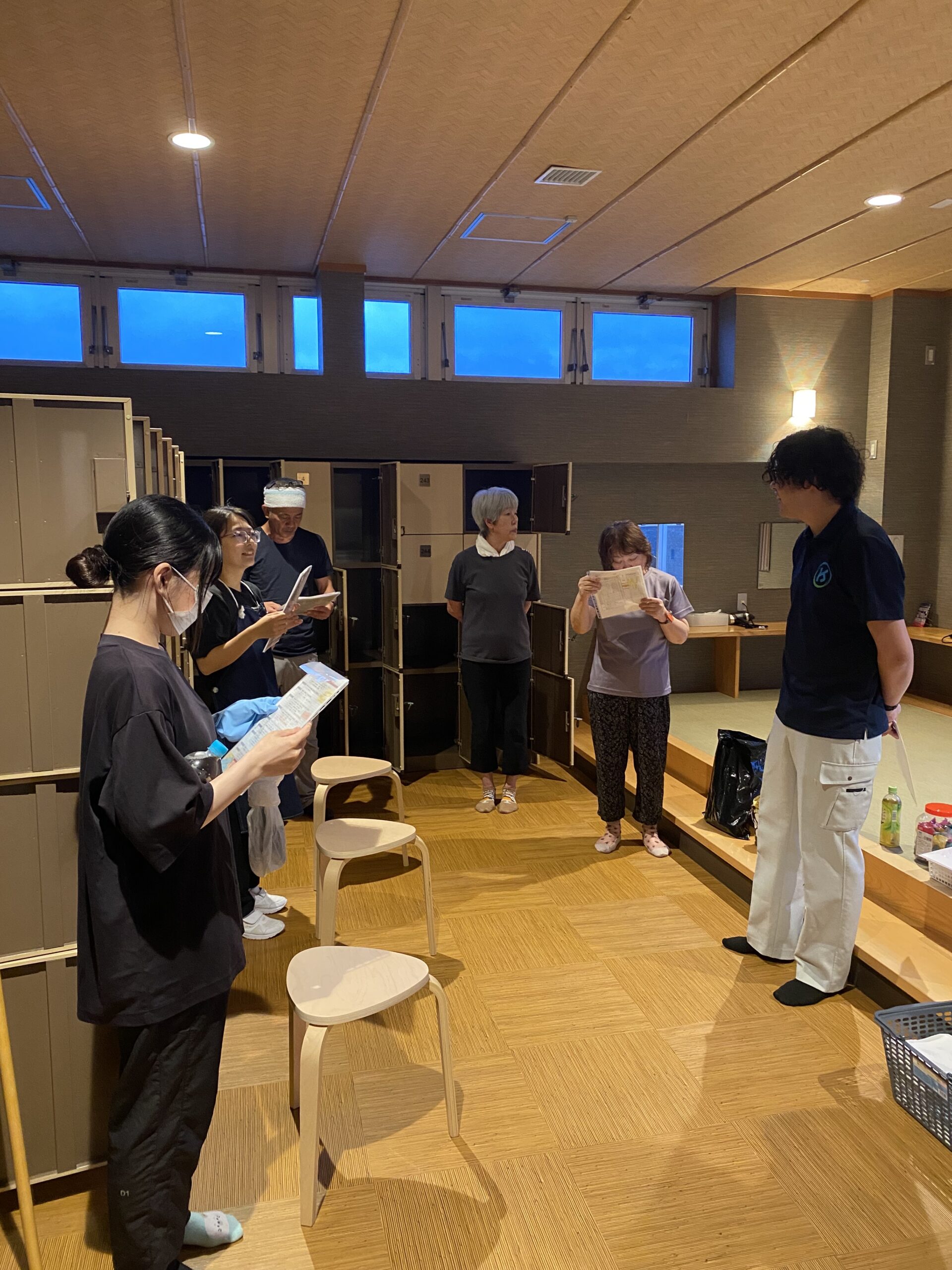 みかんの湯様で資料を手に集まるスタッフの朝礼風景